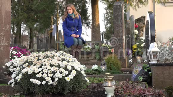 秋天悲伤的妻子坐在城市公墓的长凳上4K视频的预览图