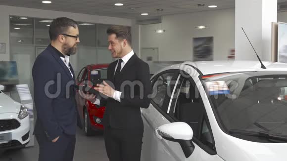 销售经理在汽车经销处向顾客解释合同视频的预览图