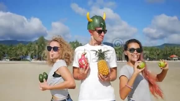 快乐美丽的年轻纯素朋友有愚蠢的乐趣在海滩和跳舞与异国情调泰国水果泰国范甘视频的预览图