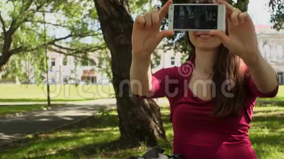 迷人的年轻女性在夏天在户外的智能手机上自拍视频的预览图