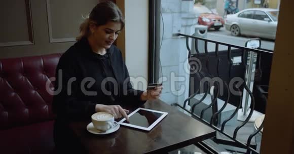 美丽的女性在线银行使用ipad购物与信用卡拍摄于红色电影院4k视频的预览图