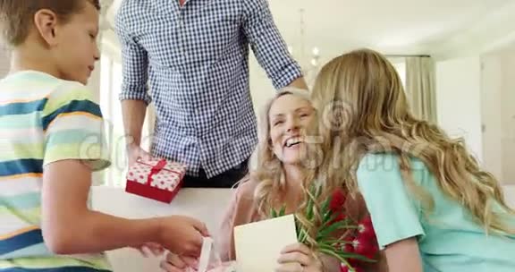 父亲带着孩子在客厅给妻子送惊喜礼物视频的预览图