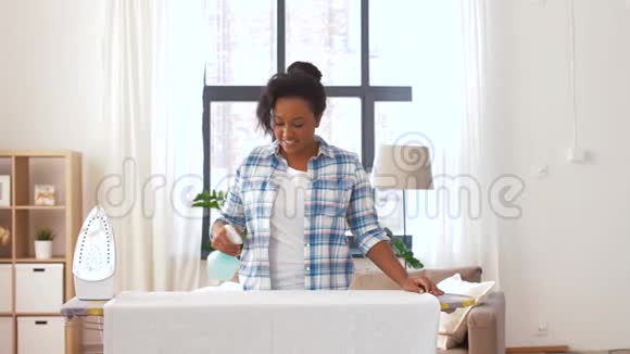 非洲裔美国妇女在家熨烫床单视频的预览图
