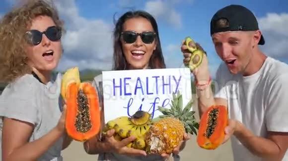 三位年轻的朋友手持健康的生活饮食搅拌手制标志和异果跳舞泰国范甘视频的预览图