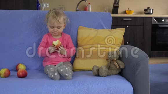 姑娘吃红鲜苹果坐沙发健康的生活方式食物4K视频的预览图