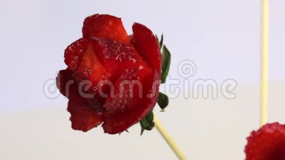 一个女人用草莓做玫瑰草莓穿在一根棍子上女人用刀切花瓣视频的预览图
