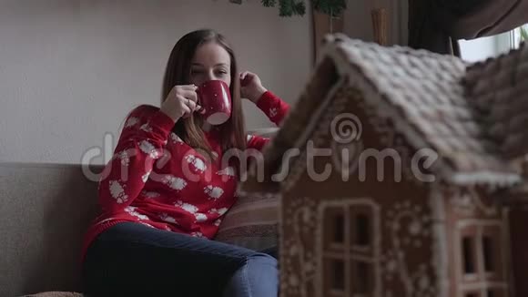 圣诞快乐假日快乐年轻女子喝着温茶和圣诞饼干视频的预览图
