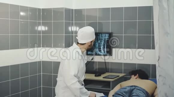 检查病人的医生在监视器上显示受伤的脊柱4k视频的预览图