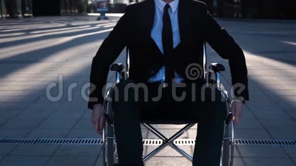 跛脚商人坐轮椅在商业中心附近的室外摄像机上移动视频的预览图