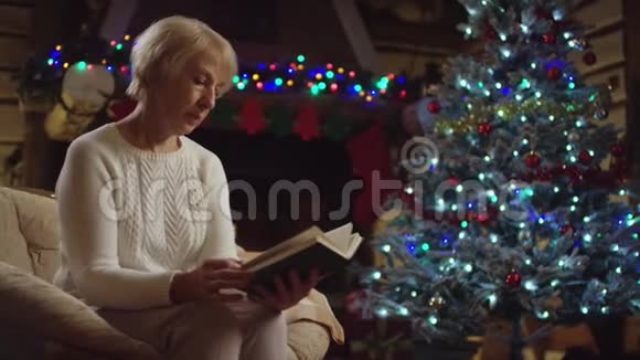 老太太在圣诞树旁看书视频的预览图