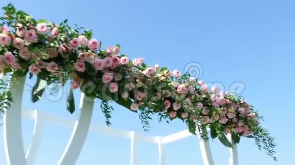 婚礼装饰用玫瑰装饰的白色婚礼拱门海滩上的婚礼婚礼的准备视频的预览图