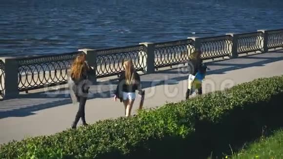 三个朋友在长板上沿着海滨散步视频的预览图