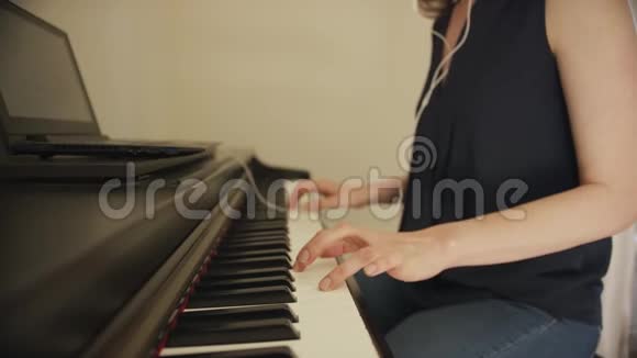 女性使用笔记本电脑弹钢琴视频的预览图