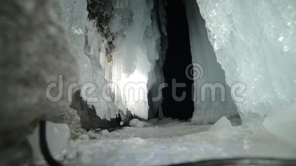 在贝加尔湖冰洞旅行的人去冬岛旅行背包客正在冰窟散步旅行者看着视频的预览图
