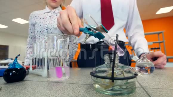 小学生在科学教室里加热试管做化学实验视频的预览图