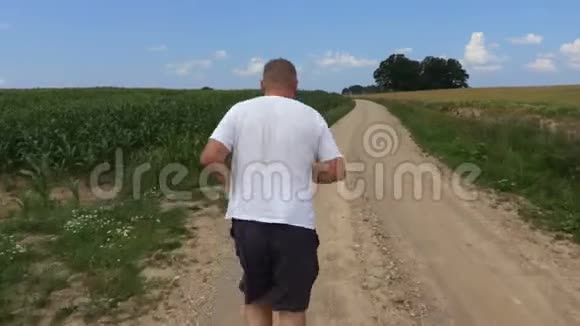 镜头跟随跑步者在乡村道路上视频的预览图