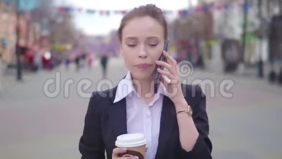 在市中心使用智能手机的年轻成功女商人职业女性雇主与商界人士交谈视频的预览图