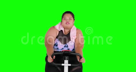体重超标的女人在运动自行车上锻炼视频的预览图