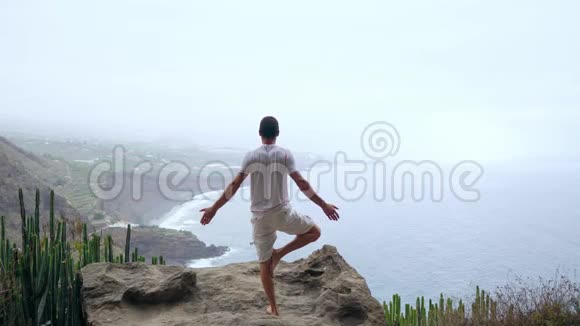 适合年轻人在山上为海洋练习太阳敬礼瑜伽年轻人喜欢冥想和瑜伽健身健身视频的预览图