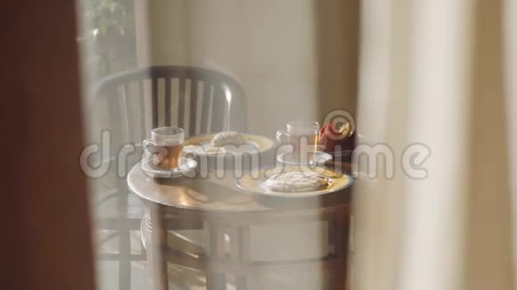 早上时间露台木桌上有透明的热红茶杯和煎饼炒饭早餐视频的预览图