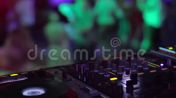 DJ设备男性手控制音频而人们跳舞放松在舞池视频的预览图