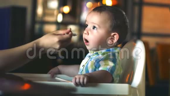 孩子和食物母亲在餐馆里用婴儿勺子给婴儿食物孩子放纵拒绝吃视频的预览图