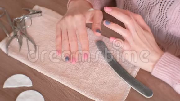 女人把奶油放在指甲周围的皮肤上然后去除凝胶波兰双手特写视频的预览图