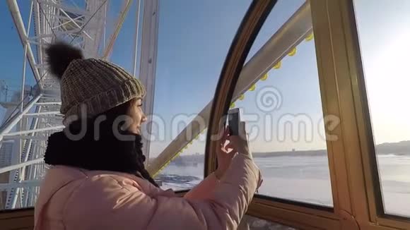 女孩在驾驶舱拍自拍的摩天轮上电话微笑视频的预览图
