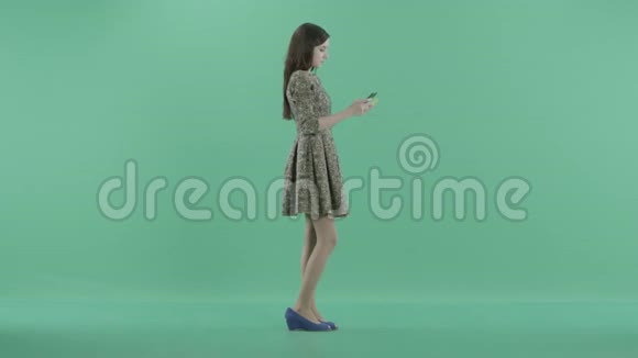 一个女孩拿着塑料卡和手机站着视频的预览图