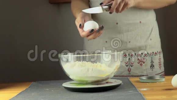 鸡蛋落在黑色背景上的一堆面粉上视频的预览图