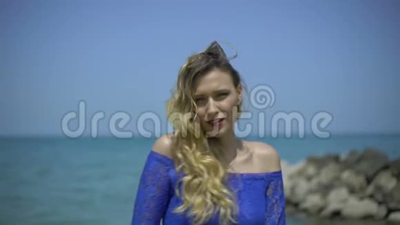 金发美女在蔚蓝的海岸海滩或码头唱歌女歌手唱歌说话跳舞表演勾引视频的预览图