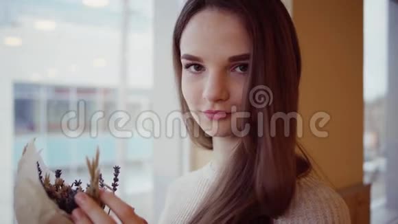 年轻漂亮的姑娘带着一束干花视频的预览图