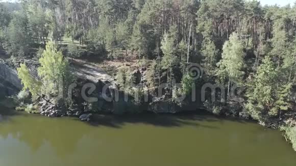 有岩石和木制码头的森林湖鸟瞰图视频的预览图