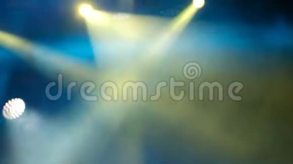 音乐会灯光和烟雾舞台上明亮的黄色和蓝色的探照灯模糊的背景录像视频的预览图