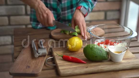 在家庭厨房的餐桌上女性的双手紧紧地捏着半个柠檬到鳄梨做鳄梨酱视频的预览图