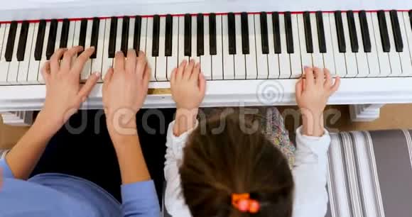 母亲协助女儿弹钢琴视频的预览图