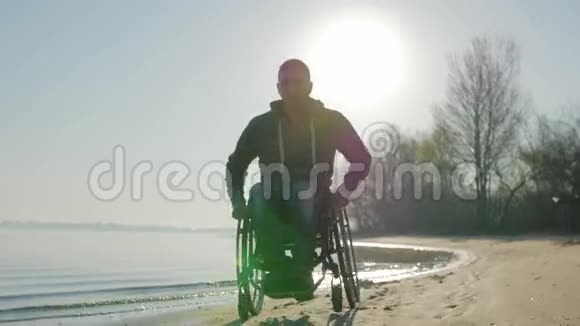 残疾人乘坐轮椅沿着海滩骑行残疾人信仰视频的预览图