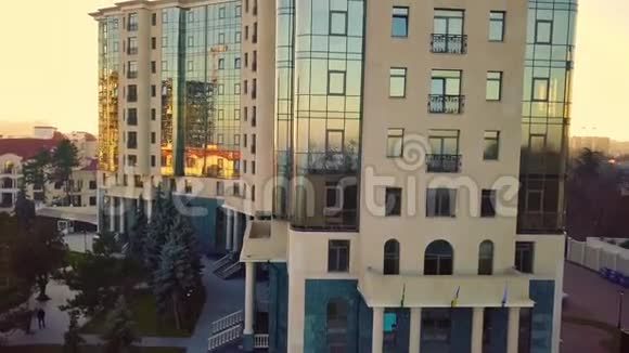 空中无人机飞行足迹在日落光线下用玻璃商务中心观看城市景观视频的预览图