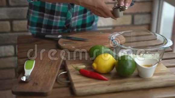 女人在厨房里捏大蒜做鳄梨酱配方视频的预览图