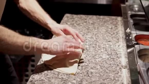 厨师用烹饪铲子把封闭的披萨封好并放进烤箱视频的预览图