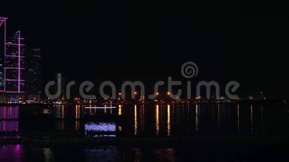 船上有霓虹灯漂浮在海泻湖前的清真寺用金色的灯光照明大城市夜景视频的预览图