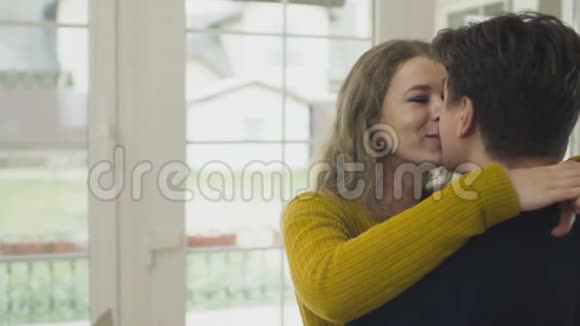 幸福的女人带着钥匙在新房子里拥抱丈夫视频的预览图
