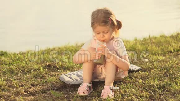 夏天日落时分小甜妹儿用管子喝新鲜的冰沙视频的预览图