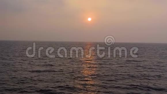慢动作空中拍摄热带日落太阳落在海洋上海水在黄昏的灯光下波涛视频的预览图