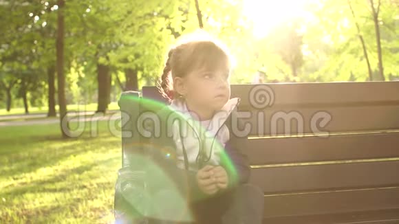 日落时坐在公园长凳上让小女孩心烦意乱视频的预览图