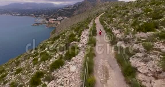 小女孩在山路上奔跑的航拍镜头视频的预览图