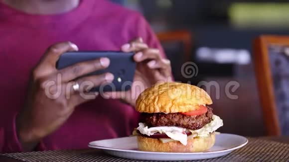 手机拍摄汉堡咖啡厅桌上的汉堡视频的预览图