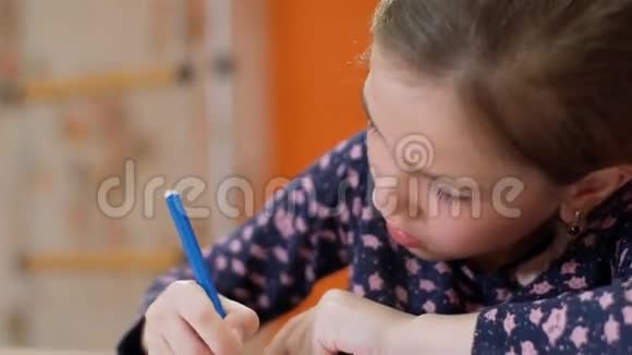 书桌前的一个小女孩画了一支蓝色的毡尖笔特写视频的预览图