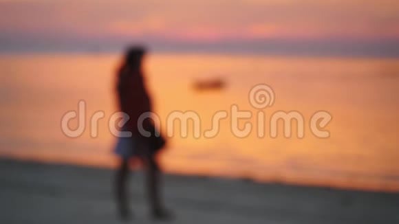 模糊的妈妈和小女孩在美丽的日落时在海滩上散步慢动作1920x1080视频的预览图