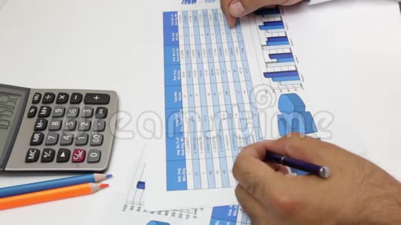 商人手里拿着计算器和笔在桌子上写和归档文件视频的预览图